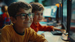 Two little boys are sitting in front of computer monitors, one of them wearing glasses. They are studying programming at IT camp