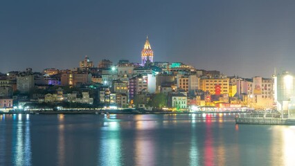 Canvas Print - Evening view over golden horn bay on the galata tower and its neighborhood day to night transition timelapse in Istanbul. Illuminated city skyline reflected on water with ship at spring day