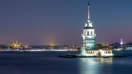 Wall Mural - Maidens tower after sunset day to night transition timelapse in istanbul, turkey, kiz kulesi tower. City skyline on background with reflection on Bosforus water