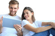 © ty - Young couple watching media content online in a tablet sitting on a sofa on a transparent background