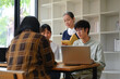 © Prathankarnpap - Happy mature professor helping group of students at university library