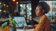© ifoto - High angle view of an African-American woman analyzing business graph on a laptop computer