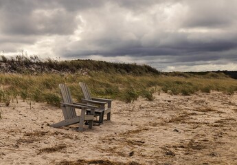 Wall Mural - Scenic view of two wooden chairs on a beach on Cape cod