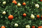 Fototapeta  - Festive New Year Christmas tree decorated red yellow Christmas balls with garlands lights, close up view, merry Christmas and happy New Year, essence of holiday cheer and joyous spirit