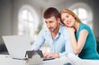 Cheerful young lovely couple use laptop