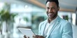 © Anastasiia - Latin businessman smiling while using a tablet in the office and looking at the camera. Concept Business, Technology, Office, Latin American, Smiling