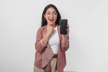 Happy young Asian business woman showing and pointing to a copy space on her phone, isolated by white background.