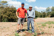 Elderly Farmer and Grandson Standing Proudly in Sunlit Field During Harvest Season