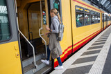 Fototapeta  - Junge Frau steigt in einen Zug
