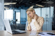 © Tetiana - Businesswoman experiencing neck pain while working on laptop in modern office