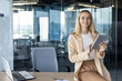 © Tetiana - Confident business woman using a tablet in modern office environment