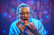 An adult woman 45 years old wearing glasses enjoys eating pizza during her lunch break.