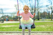 Child girl, Playing on swing Playground in spring time