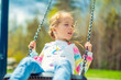 Child girl, Playing on swing Playground in spring time