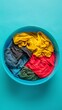 Colorful clothes ready to be washed in a plastic basin. Top view of colorful laundry clothes in a basin.