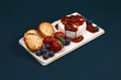 Brie or camembert cheese with strawberry, blueberry and bread on blue background. French appetizer