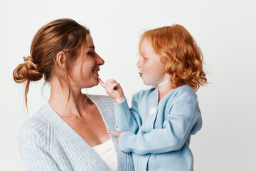 Wall Mural - Mother and child with red hair looking at camera in a loving embrace in a warm family moment