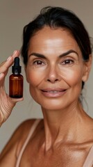 Wall Mural - Woman with radiant skin holding small bottle of beauty product.