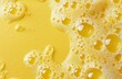 Soap foam with bubbles and water drops on a yellow surface. Soap foam with bright bubbles and a touch of freshness and dynamism on a yellow background.