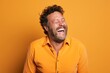 © Markus Schröder - Portrait of a satisfied man in his 40s laughing in front of pastel orange background