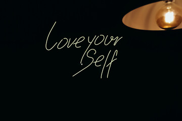 A glowing neon sign Love yourself that is often used in shop and cafe interior design.