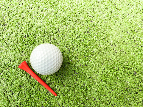 Golf balls and tees are placed on artificial grass.