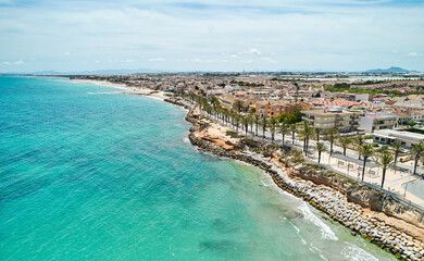 Canvas Print - Aerial shot, drone point of view panoramic image of Torre de la Horadada townscape with sandy beach, turquoise bay and city rooftops at sunny summer day. Costa Blanca, Alicante, Spain