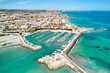 Aerial shot, drone point of view panoramic image of Torre de la Horadada townscape with sandy beach, turquoise bay waters and harbor with vessels at sunny summer day. Costa Blanca, Alicante, Spain
