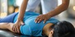 © gunzexx png and bg - A physiotherapist is performing a back treatment on a patient lying prone on a therapy table