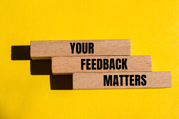 Your feedback matters written on wooden blocks with yellow background. Conceptual your feedback matters symbol. Copy space.