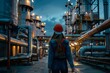 Industrial woman. A girl on the territory of the manufactory. Engineer near the night factory. Industrial high pressure tanks. Chemical factory. Female industrial engineer.