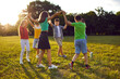 © Studio Romantic - Friendly kids boys and girls hold hands standing in circle doing outdoor activities together walking or children birthday party dressed in casual summer clothes through green sunny park