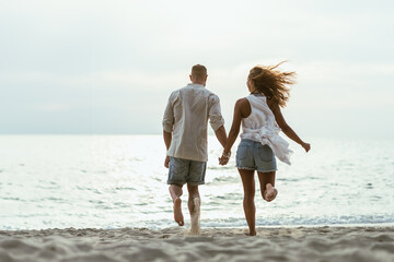 Poster - A Man and a Woman Running on a Beach Holding Hands