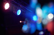Scenic colored floodlights of different colors in a nightclub on a dark blurred background with a beautiful bokeh.