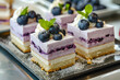 Elegant dessert slices with layers of berry mousse and cream, beautifully presented.