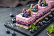 Elegant dessert slices with a vibrant berry layer on a dark textured background.