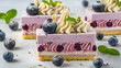 Exquisite cake slices with blueberries, cream swirls, and a berry layer on a white surface.