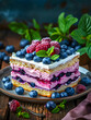 Layered berry cake with raspberries and blueberries on a ceramic plate.