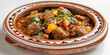 Moroccan Tagine on a white porcelain platter, white backdrop, Traditional North African cuisine