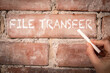File Transfer. Text written with white chalk on a red brick background
