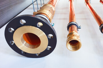 Poster - A row of copper pipes are lined up on a white surface. The pipes are of varying lengths and are connected to each other. Concept of order and organization, as the pipes are neatly arranged in a row