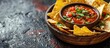 Delicious chipotle sauce and nachos in a bowl on a dark background