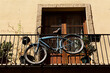 Bicicleta retro colgada del balcón de una casa.