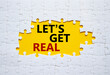 Lets get real symbol. Concept words Lets get real on white puzzle. Beautiful yellow background. Business and Lets get real concept. Copy space.