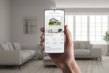 Poster - Real estate app on phone display in man hand. Property listings for an effortless home search experience
