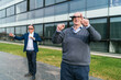© Koldo_Studio - Businessmen exploring virtual reality outside, wearing VR glasses and interacting with digital interfaces enthusiastically.