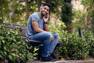 Poster - Phone call, man and college student in park, talking and smile with connection to contact and chat. University, education and person in campus with mobile, speaking and check for update in studying