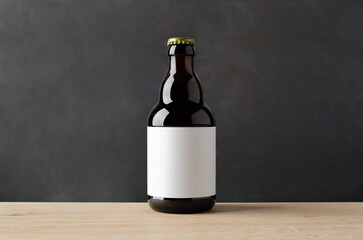 Wall Mural - Amber steinie beer bottle mockup with blank label on a wooden table and dark background.