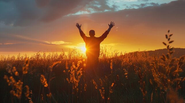On the serene backdrop of an autumn sunset meadow the silhouette of a man uplifts his hands in honor of the International Day of Peace