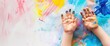 child hands covered in bright and vibrant paint, creating a colorful and artistic appearance Web banner with empty space 